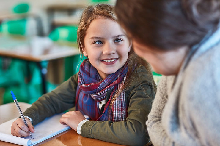 smiling child facing teacher  