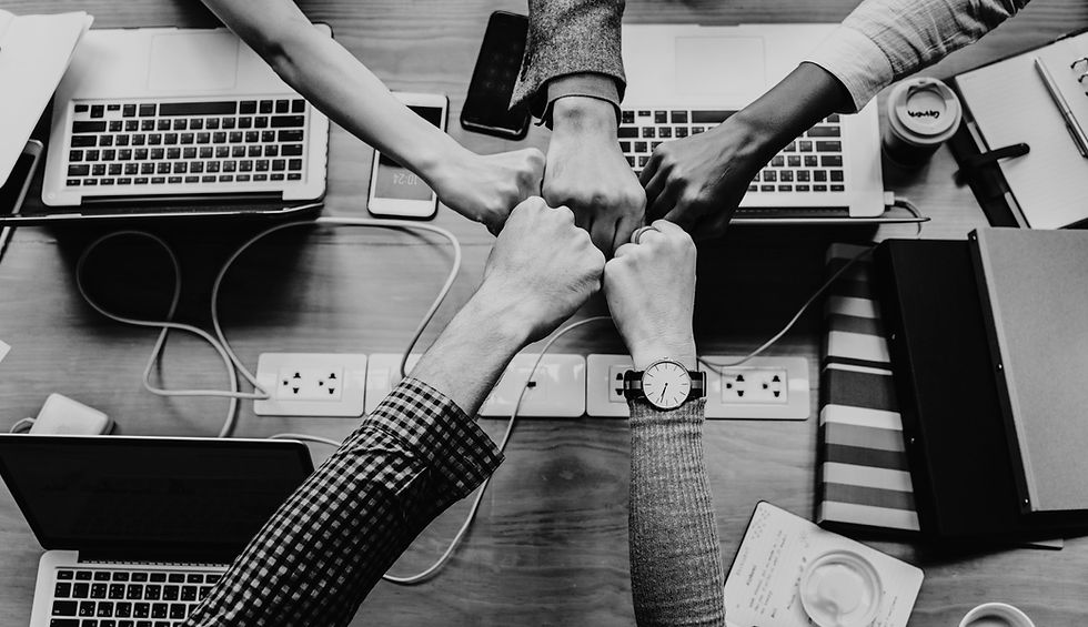 hands working together on team laptops